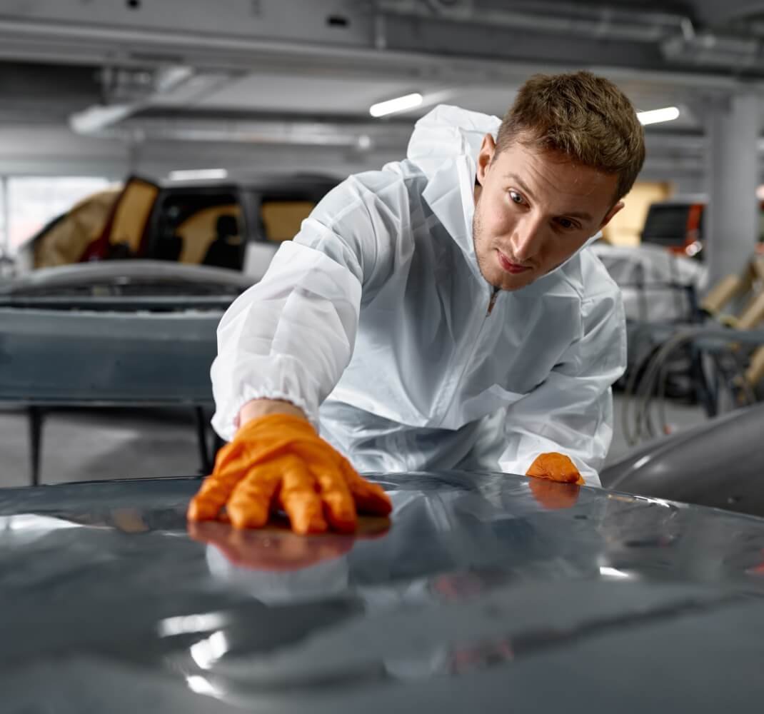 A car care professional installing ONYX COATING PPF to a gray car
