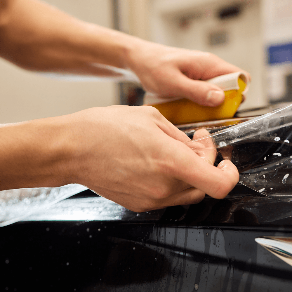 ONYX COATING installer applying PPF to black car